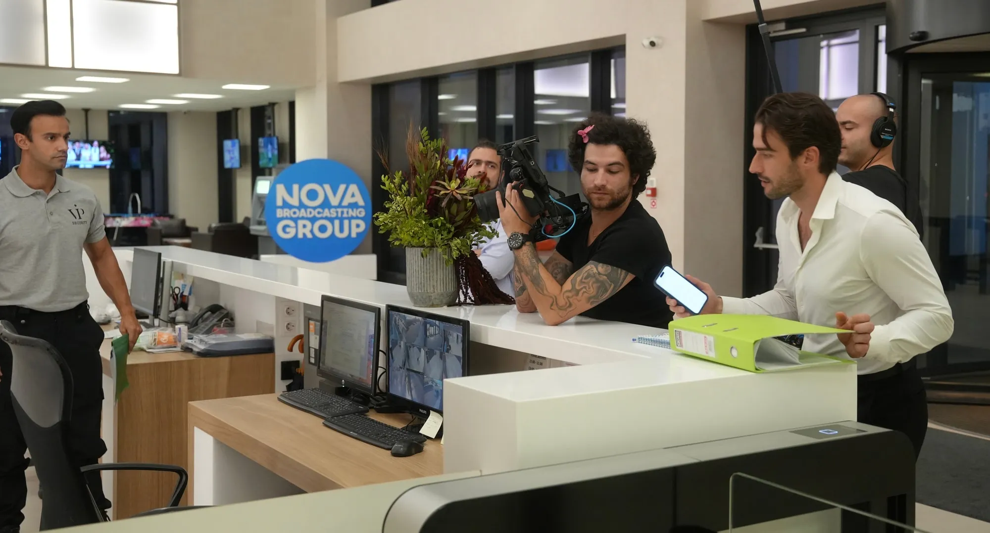 Martin Mednikarov working with a camera crew at the NOVA reception desk